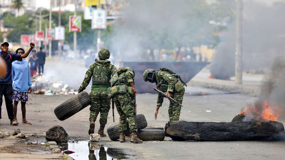 epa11760517 Military personnel remove tires from a barricade during a post-election protest, in a street of Maputo, Mozambique, 06 December 2024. In recent weeks, supporters of former presidential candidate Venancio Mondlane, who is currently in exile, have taken to the streets of the Mozambican capital to challenge the results of the disputed general election held in October 2024.  EPA/LUISA NHANTUMBO
