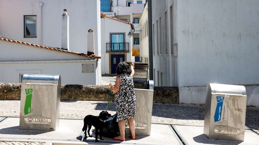 Uma mulher junto a um ecoponto no bairro da Ajuda, em Lisboa, 13 de agosto de 2024. Ecoponto. Lixo. Resíduos sólidos. Reciclagem. ANTÓNIO PEDRO SANTOS/LUSA