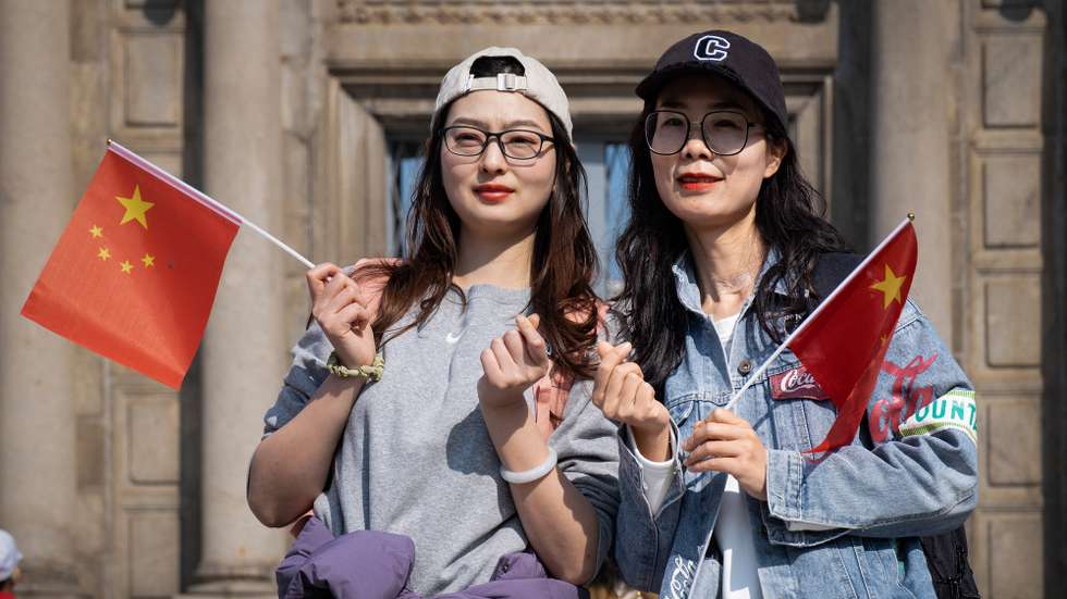 Women pose waving Chinese flags during the visit of the Chinese president to celebrate the 25th anniversary of the establishment of the MSAR in Macau, China, 19 December 2024. GONCALO LOBO PINHEIRO/LUSA