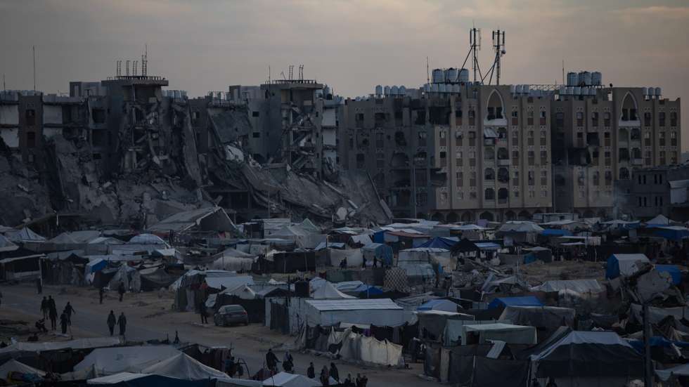 epa11790133 Displaced Palestinians, who fled their homes due to Israeli airstrikes and evacuation orders, walk among tents in a makeshift camp at sunset in Khan Younis camp, southern Gaza Strip, 22 December 2024. According to the UN, at least 1.9 million people (or nine in ten people) across the Gaza Strip are internally displaced, including people who have been repeatedly displaced. Since October 2023, only about 11 percent of the Gaza Strip has not been placed under Israeli-issued evacuation orders, the UN aid coordination office OCHA said.  EPA/HAITHAM IMAD