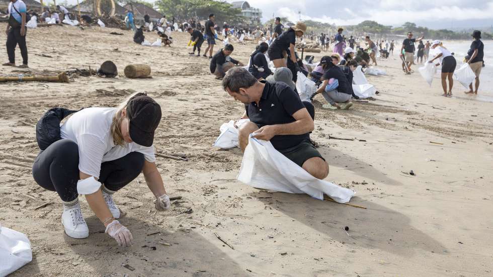 epa11804574 Locals and tourists participate in a beach cleanup event at Kedonganan Beach in Bali, Indonesia, 04 January 2025. Numerous waste ends up in the sea during Indonesia's rainy season, which lasts between November and April.  EPA/MADE NAGI