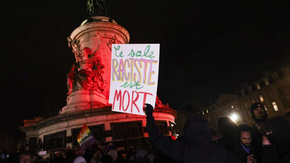 epa11811829 A man displays a sign reading 'The Dirty Racist is Dead' during a gathering at Place de la Republique in Paris, France, 07 January 2025, to celebrate the death of Jean-Marie Le Pen, the former leader of the Front National. French politician Le Pen passed away on 07 January 2025, aged 96.  EPA/TERESA SUAREZ