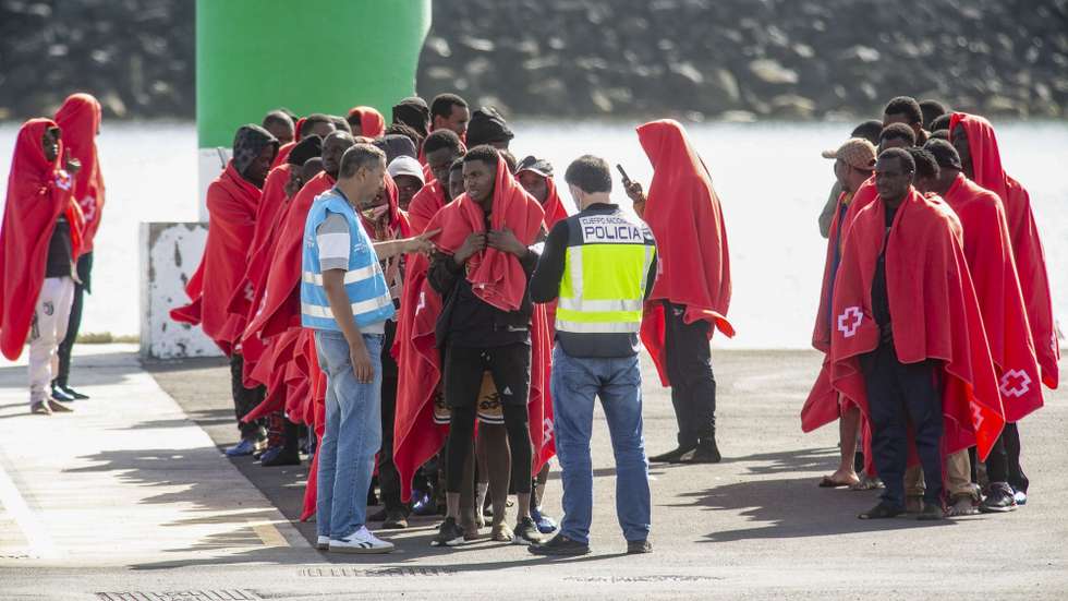 epa11807545 A Spanish police officer (C-R) and a Frontex officer (C-L) receive migrants upon their arrival at the port of the town of Arrecife, Lanzarote Island, Canary Islands, southwestern Spain, 05 January 2025. The Spanish Maritime Rescue Service rescued a small wooden boat with 67 persons on board near Lanzarote.  EPA/ADRIEL PERDOMO