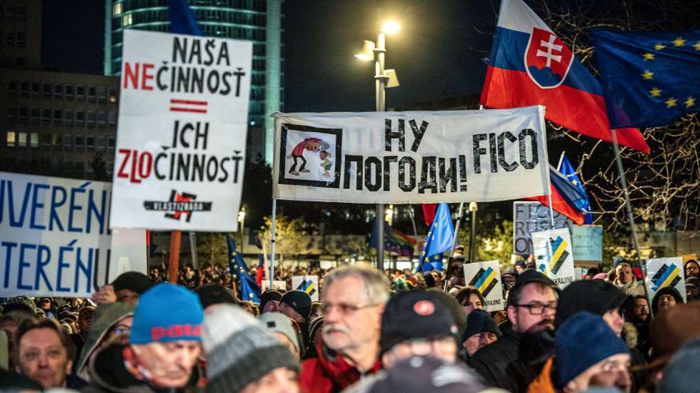 epa11817191 People wave flags and hold placards during a demonstration against the Slovak prime minister, in front of the Government Office building, in Bratislava, Slovakia, 10 January 2025. The protests, titled 'Slovakia is Europe- Enough of Russia!', were sparked by Prime Minister Robert Fico's meeting with Russian President Vladimir Putin in Moscow in December 2024.  EPA/JAKUB GAVLAK