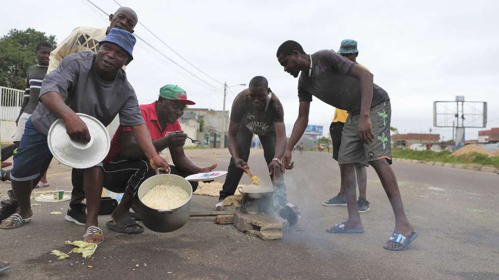 Um cenário de caos, barricadas, destruição e saques marca hoje a cidade de Maputo, um dia depois da proclamação dos resultados das eleições gerais, mas no meio das mesmas avenidas, bloqueadas por manifestantes, também se cozinha arroz com repolho, Maputo, Moçambique, 24 de dezembro de 2024. LUÍSA NHANTUMBO/LUSA