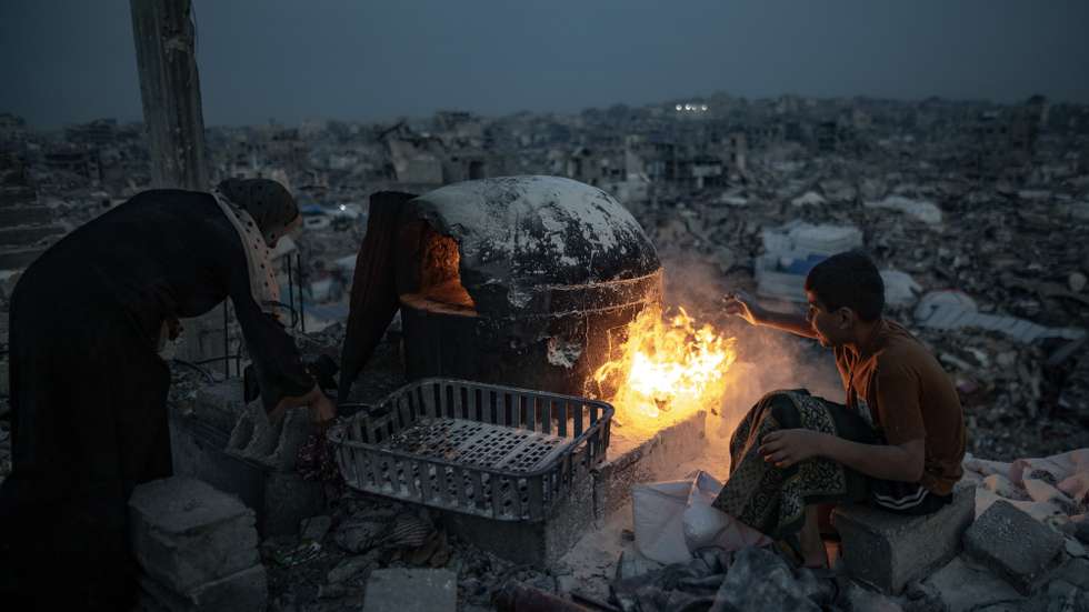 epa11970625 The Maarouf family prepares iftar over a fire in the rubble of their destroyed home during the holy month of Ramadan in Jabalia refugee camp, northern Gaza Strip, 17 March, 2025.  EPA/HAITHAM IMAD