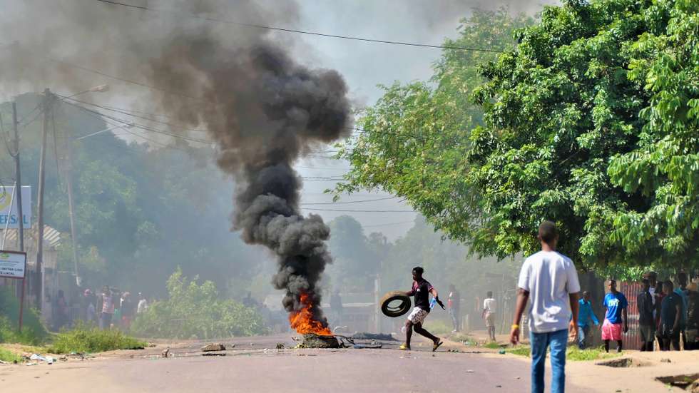 epa11944223 A man places a tire in a bonfire in the middle of a street during a protest in the Patrice Lumumba neighborhood in the city of Matola, Mozambique, 06 March 2025. Police carried out operations to stop demonstrators protesting against the shooting of Mozambican politician Venancio Mondlane's convoy on 05 March in Maputo.  EPA/ESTEVAO CHAVISSO