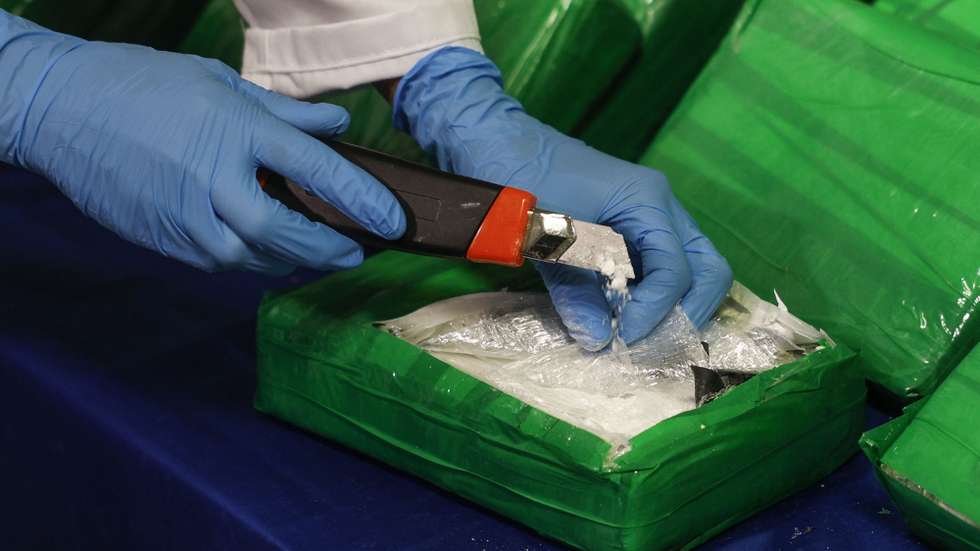 Uma agente da Polícia Judiciária (PJ), mostra o interior de embalagens de cocaína escondidas em caixas de bananas, após a sua apreensão na operação "Acácias", em Lisboa, 30 de dezembro de 2024. A operação foi realizada nos últimos dias pela Unidade Nacional de Combate ao Tráfico de Estupefacientes, de localização e apreensão de cerca de três toneladas e meia de cocaína chegadas a território nacional por um porto marítimo. ANTÓNIO PEDRO SANTOS/LUSA