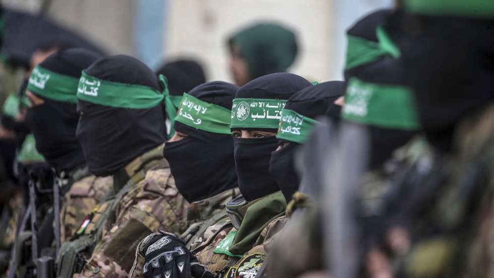 epa11915750 Armed fighters from Hamas' Izz ad-Din al-Qassam Brigades stand guard during the handover of three Israeli hostages to Red Cross representatives in Al Nuseirat refugee camp, central Gaza Strip, 22 February 2025. Six Israeli hostages were released on 22 February -- three in Nuseirat, two in Rafah and one in Gaza City -- after Hamas handed them over to the Red Cross in Gaza as part of the first phase of the Israel-Hamas ceasefire deal.  EPA/MOHAMMED SABER