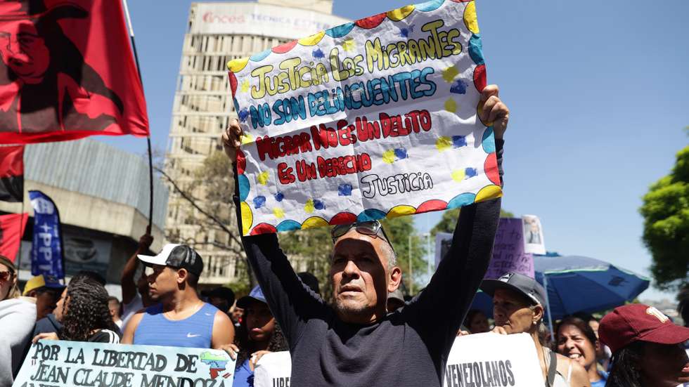 epa11988502 A person holds a sign during a demonstration called by Chavismo, in support of Venezuelan migrants deported from the United States to El Salvador in Caracas, Venezuela, 25 March 2025.  EPA/RONALD PENA R
