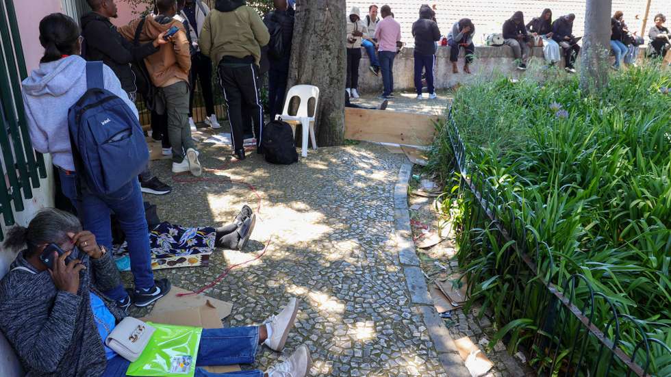 Dezenas de imigrantes, na maioria angolanos, aguardam há dias a validação dos seus documentos na Direção Geral dos Assuntos Consulares (DGAC),  junto à qual várias pessoas têm dormido na rua, em cima de cartões, para assegurar o atendimento, Lisboa, 21 de maio de 2025.  MANUEL DE ALMEIDA/LUSA
