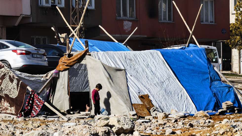 Uma criança brinca junto de uma tenda improvisada num campo de deslocados sírios, em Gaziantepe, Turquia, 15 de fevereiro de 2023. Desde o terramoto de 6 de fevereiro, mais de 40.000 pessoas já morreram na Turquia e na Síria. JOÃO RELVAS/LUSA