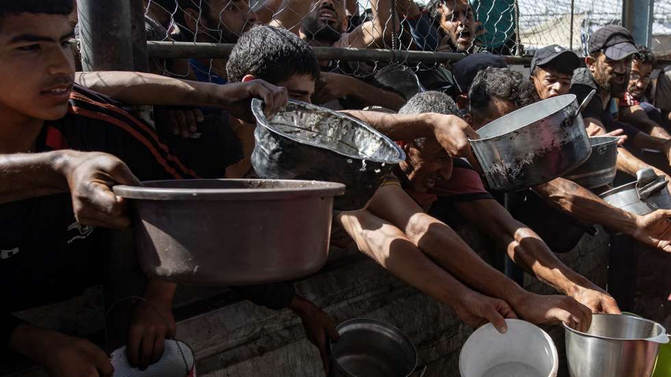 epa12144624 Internally displaced Palestinians gather outside a charity kitchen to receive limited rations amid a shortage of food, in Khan Younis, southern Gaza Strip, 30 May 2025. The United Nations has warned that "the entire population of Gaza is facing the risk of famine" since Israel closed border crossings on 02 March 2025, preventing the entry of essential supplies. The Gaza Government Media Office reported on 24 May that at least 58 people died due to malnutrition, and nearly 250 others due to a lack of food and medicine.  EPA/HAITHAM IMAD