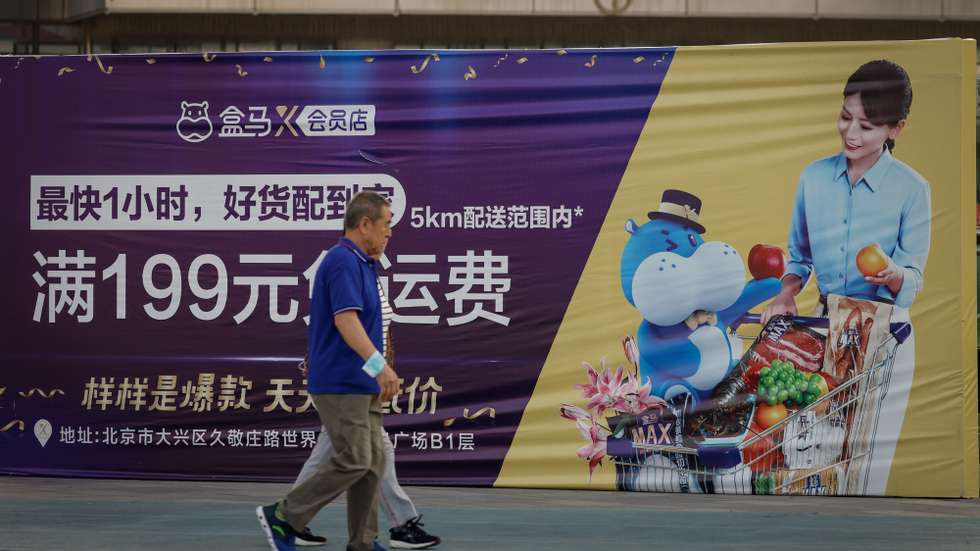 epa10207504 Elderly people walk past an advertisement from a supermarket in Beijing, China, 26 September 2022. China's yuan touched a 28-month low against the US dollar, despite the central bank taking steps to rein in the currency's weakness. The People's Bank of China (PBOC) announced that it will raise the foreign exchange risk reserves for financial institutions when buying foreign currencies through forwards contracts to twenty percent from the current zero from 28 September onwards.  EPA/MARK R. CRISTINO