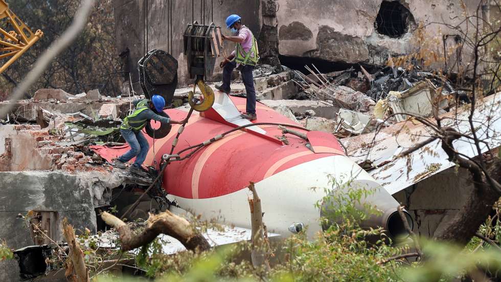 epa12174861 Indian workers remove the wreckage of the Air India passenger plane with the help of a crawler crane from the crash site, near Sardar Vallabhbhai Patel International Airport in Ahmedabad, Gujarat state, western India, 14 June 2025. Air India flight AI171, bound for London carrying 242 passengers and crew members on board a Boeing 787-8 aircraft, crashed minutes after take-off in the Meghaninagar area of Ahmedabad on 12 June.  EPA/RAJAT GUPTA