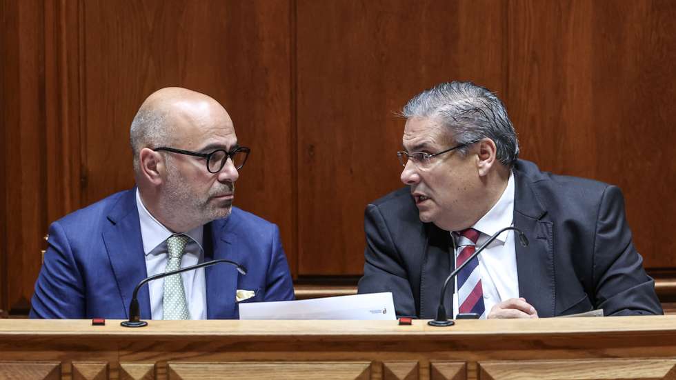 O ministro dos Assuntos Parlamentares, Carlos Abreu Amorim (D), conversa com o ministro das Infraestruturas e Habitação, Miguel Pinto Luz, durante o debate de urgência, requerido pelo Chega, sobre "Privatização da TAP", Assembleia da República, em Lisboa, 11 de julho  de 2025. ANTÓNIO COTRIM/LUSA
