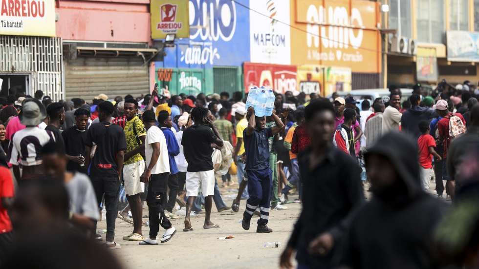 epa12269031 People loot one of Arreiou's shops, barricaded roads, and burned tires in the Calemba 2 neighborhood in the municipality of Kilamba Kiaxi on the first day of the taxi strike in Luanda, Angola, 28 July 2025. Angolan taxi drivers’ associations have called for a strike until 30 July in the main Angolan provinces as a form of protest against the increase in diesel prices at the beginning of this month, which led to an increase in public transport fares.  EPA/AMPE ROGERIO