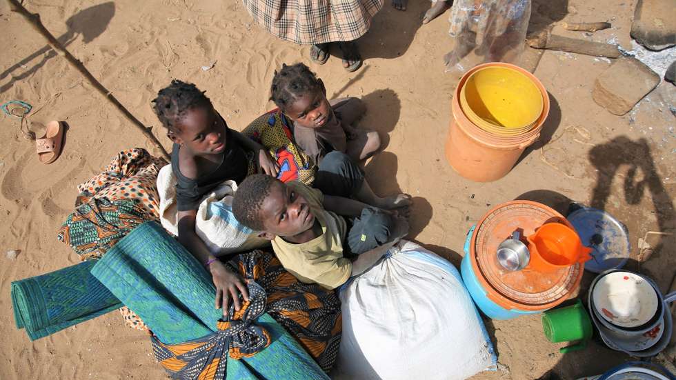 Crianças no Centro de Trânsito de Namissir, na Escola Primária Completa dos Coqueiros, que alberga mais de 5.000 famílias deslocadas devido a ataques de grupos armados em Chiúre, na província de Cabo Delgado, norte de Moçambique, 29 de julho de 2025. Uma mulher cozinha acompanhada de duas crianças no Centro de Trânsito de Namissir, na Escola Primária Completa dos Coqueiros, que alberga mais de 5.000 famílias deslocadas devido a ataques de grupos armados em Chiúre, na província de Cabo Delgado, norte de Moçambique, 29 de julho de 2025. Vários distritos de Cabo Delgado, sobretudo Chiúre, estão a registar uma crescente atividade por parte de elementos destes grupos nos últimos dias. Na semana passada, extremistas reivindicarem também a decapitação, em locais diferentes, de pelos menos três cristãos moçambicanos. (ACOMPANHA TEXTO DA LUSA DO DIA 09 DE AGOSTO DE 2025). LUÍSA NHANTUMBO
