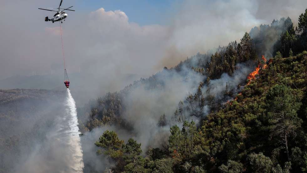 epa12310897 A helicopter drops water during a forest fire in Adurao, Pampilhosa da Serra, Portugal, 19 August 2025. Portugal activated the European Civil Protection Mechanism, which sent two Fire Boss aircraft to help fight the fires. According to preliminary official data, as of August 19, 2025, over 201,000 hectares had burned in Portugal, surpassing the total burned in all of 2024.  EPA/PAULO NOVAIS