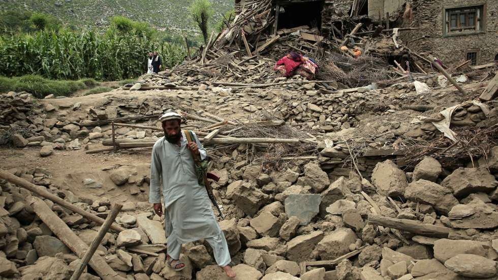 epa12344220 A man walks over rubble next to a damaged house after an earthquake in Kunar, Afghanistan, 01 September 2025. At least 800 people have been killed and some 2,000 injured after a shallow magnitude-6.0 earthquake and several aftershocks shook Nangarhar and Kunar in eastern Afghanistan overnight, officials reported on 01 September 2025.  EPA/SAMIULLAH POPAL
