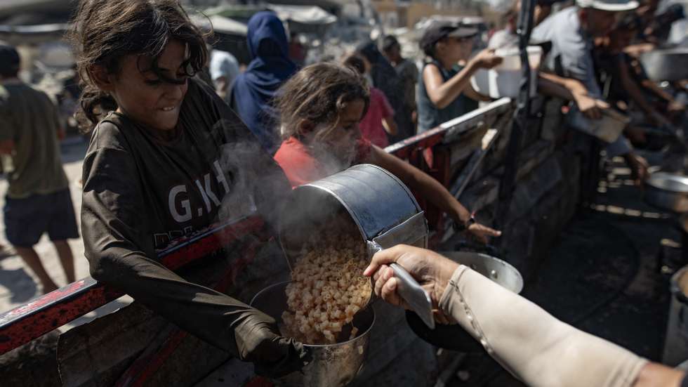 epa12370815 Palestinians, including children, hold pots as they queue to receive food from a kitchen that provides free food for displaced people in Gaza City, northern Gaza Strip, 12 September 2025. According to the UN, around 90 percent of the population, or 1.9 million people, in Gaza have been displaced since the start of the conflict.  EPA/HAITHAM IMAD