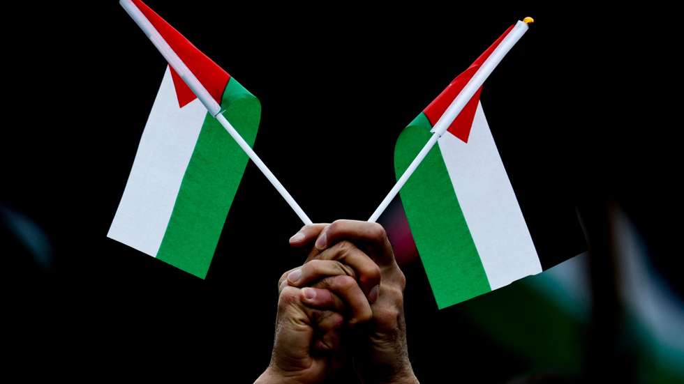 epa12373605 A person holds a Palestinian flags during a demonstration under the slogan 'No weapons in war zones! Peace instead of arms race! Stop the genocide in Gaza!' organized by the Sahra Wagenknecht Alliance (BSW) party in Berlin, Germany, 13 September 2025.  EPA/FILIP SINGER