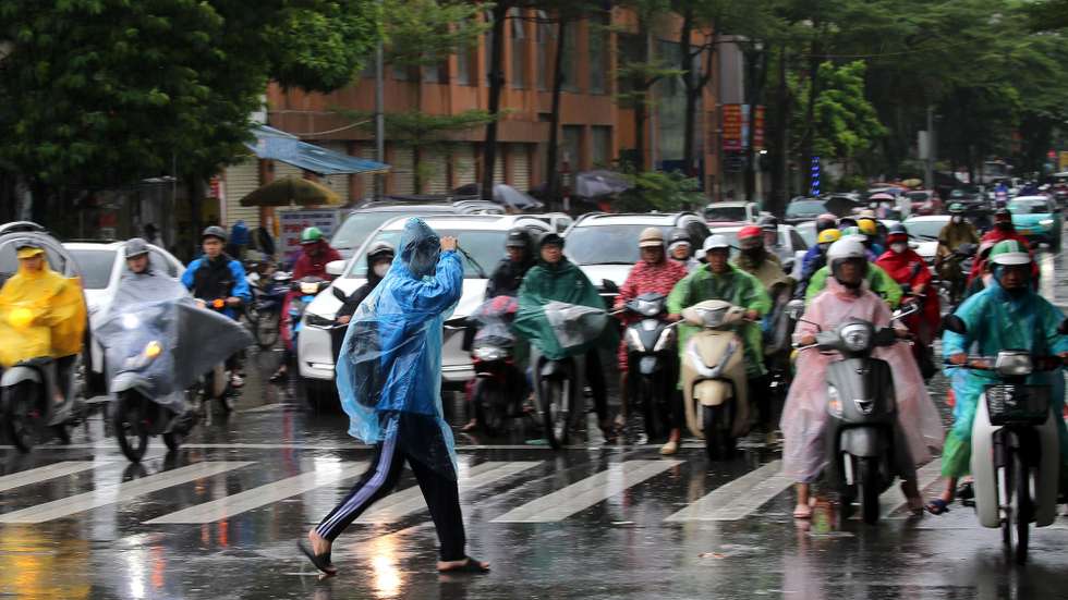 epa12413882 People riding motorbikes wait at a traffic light in the rain in Hanoi, 29 September 2025. Thirteen people were reported dead and several missing as Typhoon Bualoi made landfall in Vietnam, according to state media.  EPA/LUONG THAI LINH