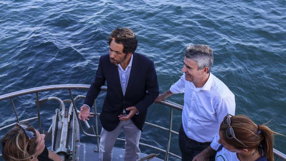 O secretário-geral do Partido Socialista (PS), José Luis Carneiro, ouve explicações do candidato socialista à Câmara municipal de Sesimbra, Sérgio Faias (E), durante um passeio num navio de pesca, numa acão de campanha no âmbito das próximas eleições autárquicas do dia 12 de outubro, Lisboa, 7 de outubro de 2025. TIAGO PETINGA/LUSA