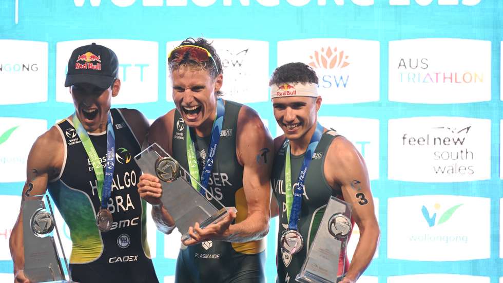 epa12464187 Matthew Hauser of Australia celebrates after winning the the Elite Men’s final and being crowned World Champion along with second place Miguel Hidalgo (left) of Brazil and  third place Vasco Vilaca (right) of Portugal at the World Triathlon Championships in Wollongong, Australia, 19 October 2025.  EPA/DEAN LEWINS AUSTRALIA AND NEW ZEALAND OUT
