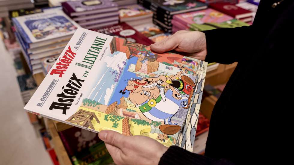 epa12474978 A bookseller holds the new comic book 'Asterix in Lusitania' on sale at a bookstore in Paris, France, 23 October 2025. Asterix in Lusitania by Didier Conrad and Fabcaro is released today in 19 languages and marks the 41st album in The Adventures of Asterix series since 1960.  EPA/Teresa Suarez