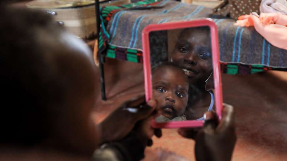 epa09030770 A Kenyan teenage mother (C), looks on the mirror as she plays with her baby during her lunch break at the Serene Haven Girls Secondary School, in Kiawara in Kieni, Nyeri, Kenya, 10 February 2021 (issued 23 February 2021). The private school in Central Kenya was founded by Elizabeth Wanjiru Muriuki with an aim to open doors to teenage pregnant girls, teenage mothers, and their babies, as a second chance by ensuring they get an education despite the stigma. The school hosts at least 20 girls with 8 pregnant and 12 already delivered who either got pregnant or gave birth during the country’s lockdown due to COVID-19. The school allows the teenage mothers to live with their babies in their dormitories where they come to attend to them during their break times from their classes.  EPA/DANIEL IRUNGU
