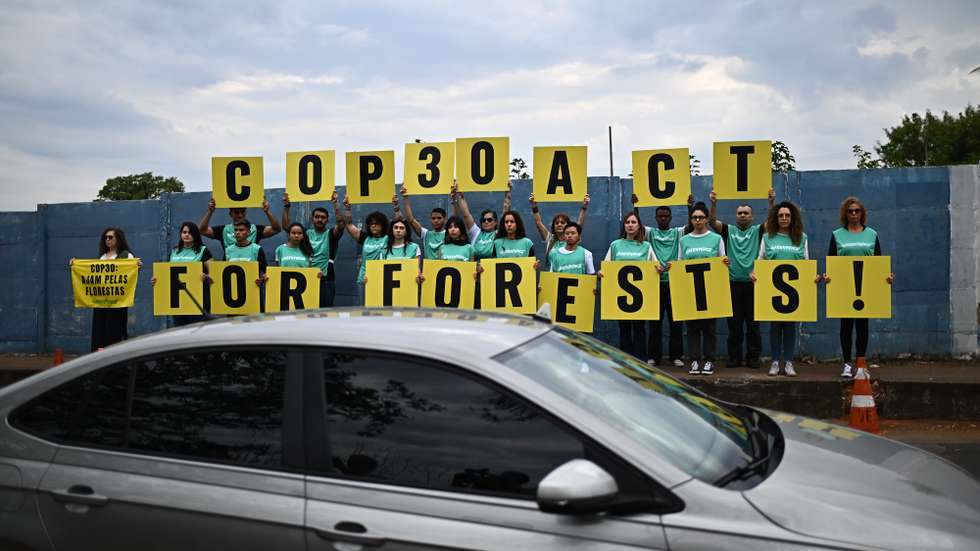 epa12451222 Greenpeace environmental activists hold signs before the opening session of the PRE-COP30 meeting at the International Convention Center in Brasilia, Brazil, 13 October 2025. during the meeting, the Brazilian presidency of COP30 urged the world to take concrete action against global warming.  EPA/ANDRE BORGES