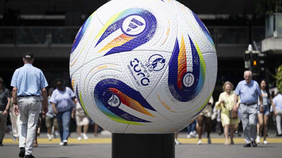 epa12198870 People walk past a giant soccer ball announcing the UEFA Women’s Euro 2025 tournament in Bern, Switzerland, 26 June 2025. The UEFA Women’s Euro 2025 will take place from 2 to 27 July 2025.  EPA/ANTHONY ANEX