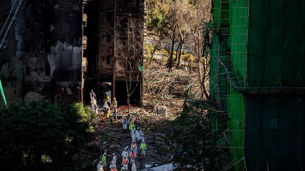 epaselect epa12556658 Firefighters and Disaster Victim Identification (DVI) unit personnel leave a fire-ravaged tower at the Wang Fuk Court residential estate in Hong Kong, China, 29 November 2025. The city is mourning 128 people killed in the high-rise apartment fire, with about 200 others still unaccounted for.  EPA/LEUNG MAN HEI