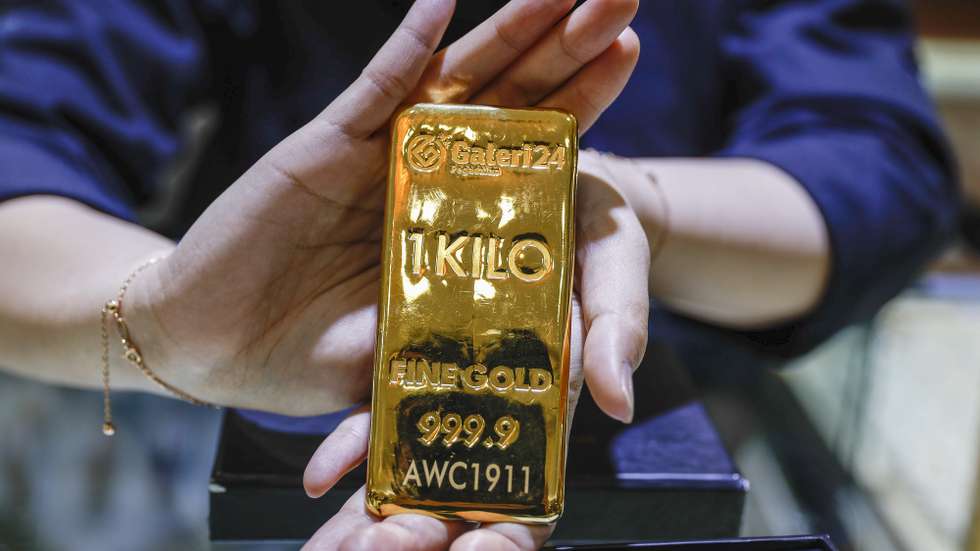 epa12440994 A shopkeeper shows a one-kilogram gold bar at the Galeri 24 gold store in Jakarta, Indonesia, 09 October 2025. The spot price of gold has risen above 4,000 US dollars per ounce for the first time, as investors turn to the precious metal amid global political and economic uncertainty.  EPA/MAST IRHAM