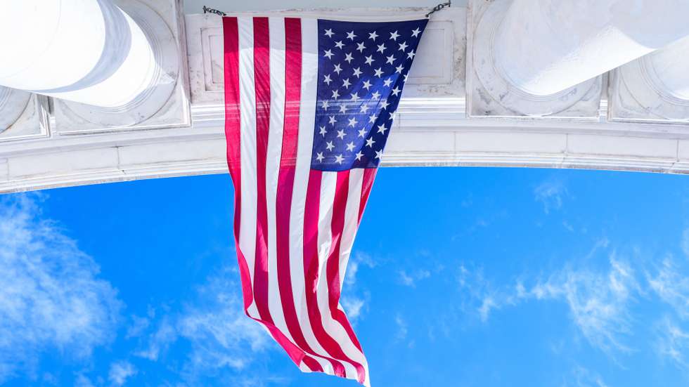 epa12519125 An American flag flies in the wind during a Veterans Day ceremony at Arlington Cemetery, Arlington, VA, USA, 11 November 2025.  EPA/AARON SCHWARTZ