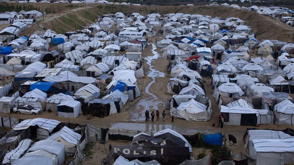 epa12646598 Displaced Palestinians inspect their tents amid heavy rainfall west of Khan Younis city, southern Gaza Strip, 13 January 2026. Thousands of homes have been destroyed, leaving families without secure shelter, as deteriorating humanitarian conditions persist across the Gaza Strip amid intensifying winter weather.  EPA/HAITHAM IMAD