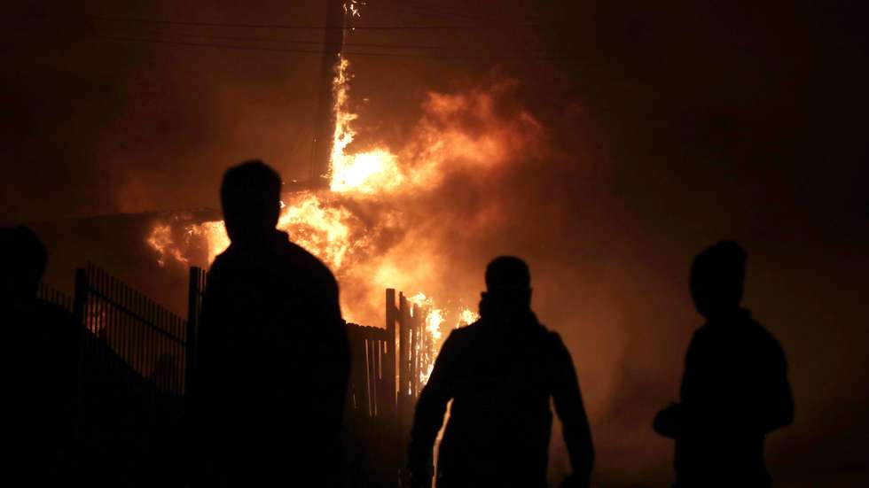 epa12659007 Houses affected by forest fires burn in Penco, Chile, 18 January 2026.  EPA/PATRICIO AGUAYO
