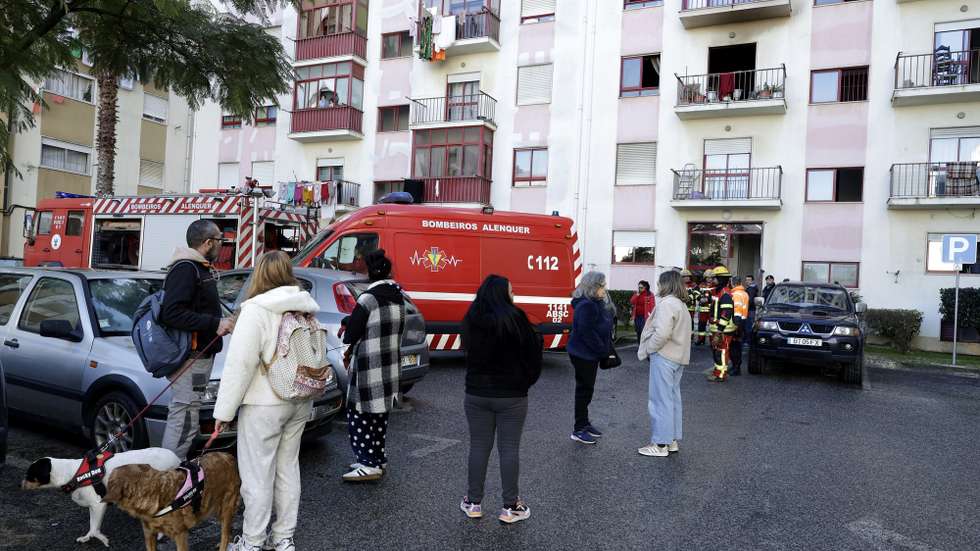 Populares e forças de segurança durante o rescaldo de um incêndio em prédio de oito pisos que provocou um morto e onze feridos, no Carregado, 19 de janeiro de 2026. MARCOS BORGA / LUSA