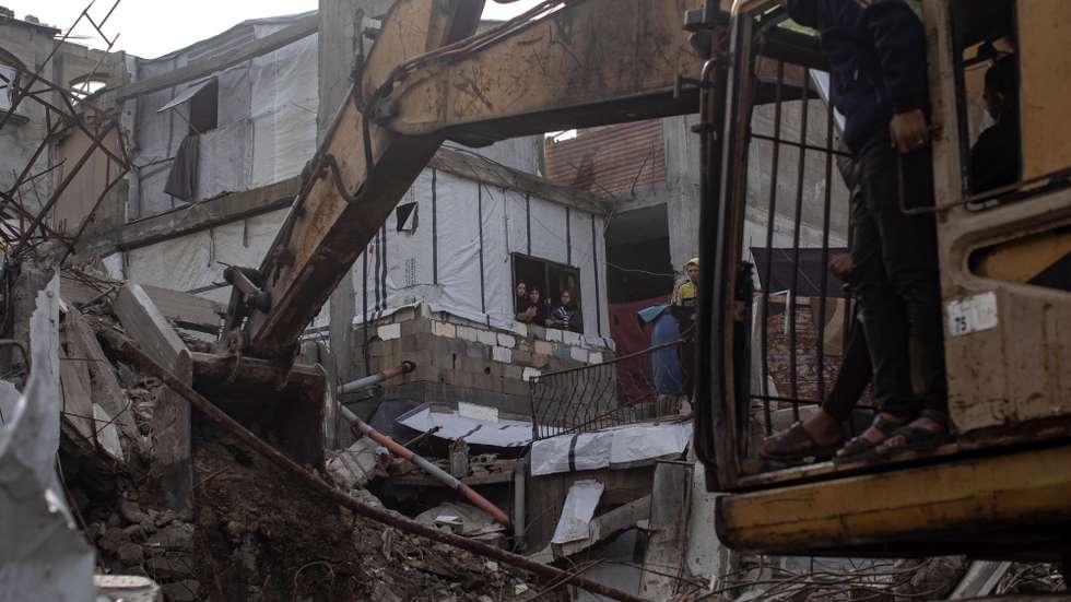 epa12604742 Palestinians watch members of the Palestinian Civil Defense removing the rubble of a destroyed home as they search for the bodies of Palestinians killed during the conflict in Khan Younis, southern Gaza Strip, 20 December 2025. The Civil Defence in the Gaza Strip is carrying out operations to recover the bodies of Palestinians buried beneath the rubble of homes destroyed during Israeli strikes on Gaza, estimating that nearly 100 bodies remain unrecovered. More than 70,000 Palestinians have been killed in the Gaza Strip since October 2023, according to the Palestinian Ministry of Health, and about 1,200 Israelis have been killed since the launch of an Israeli military campaign in response to a cross-border attack by Hamas on 07 October 2023.  EPA/HAITHAM IMAD
