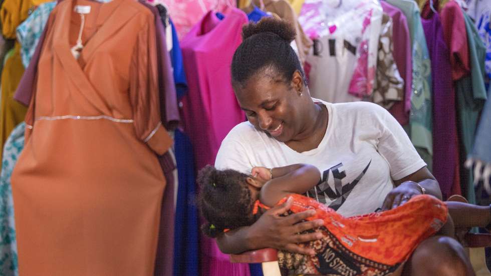 A vendedora Ana Martins com sua  filha ao colo no Sucupira, o principal mercado da Cidade da Praia, onde  muitas crianças praticamente nascem e crescem acompanhando as mães no seu dia-a-dia de trabalho, Cidade da Praia, Cabo Verde, 14 de agosto de 2024. (ACOMPANHA TEXTO DE 17-08-2024) ELTON MONTEIRO/LUSA