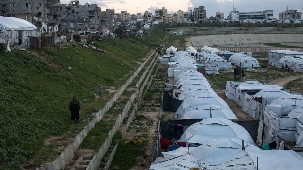 epa12659223 Displaced Palestinians by their tents in a temporary camp set up in the city of Khan Younis, in the southern Gaza Strip, 18 January 2026. According to the UN around 90 percent of the population or 1.9 million people in Gaza have been displaced since the start of the conflict.  EPA/HAITHAM IMAD