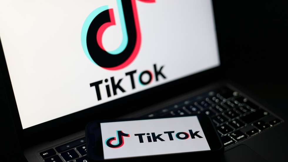 epa12674797 The TikTok logo displayed on a mobile phone and on a laptop screen in Liverpool, Britain, 23 January 2026. A proposal to ban under-16s from accessing social media in the UK will be considered in the House of Commons after peers in the House of Lords voted 261 to 150 in favour of an amendment to the Children’s Wellbeing and Schools Bill. If adopted, the amendment would require social media companies to implement strict and effective age checks in order to prevent underage users from signing up.  EPA/ADAM VAUGHAN