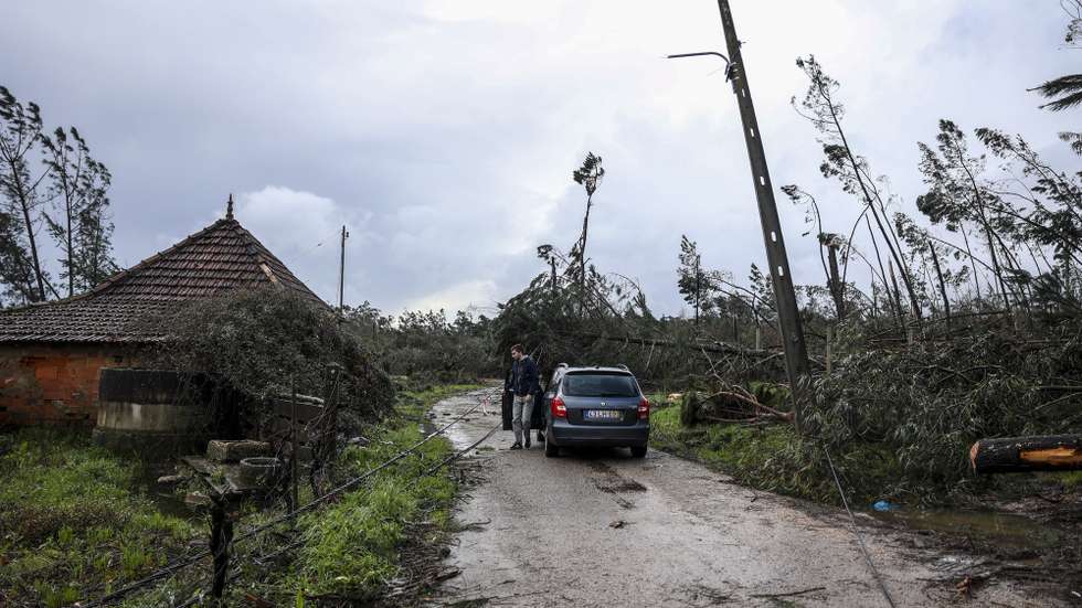 Um popular desvia cabos de eletricidade para passar numa estrada no Casalinho em Ourém, 2 de fevereiro de 2026. A passagem da depressão Kristin por Portugal continental, na quarta-feira, dia 28 de janeiro, deixou um rasto de destruição, causando pelo menos cinco mortos, segundo a Proteção Civil, vários feridos e desalojados. MIGUEL A. LOPES/LUSA