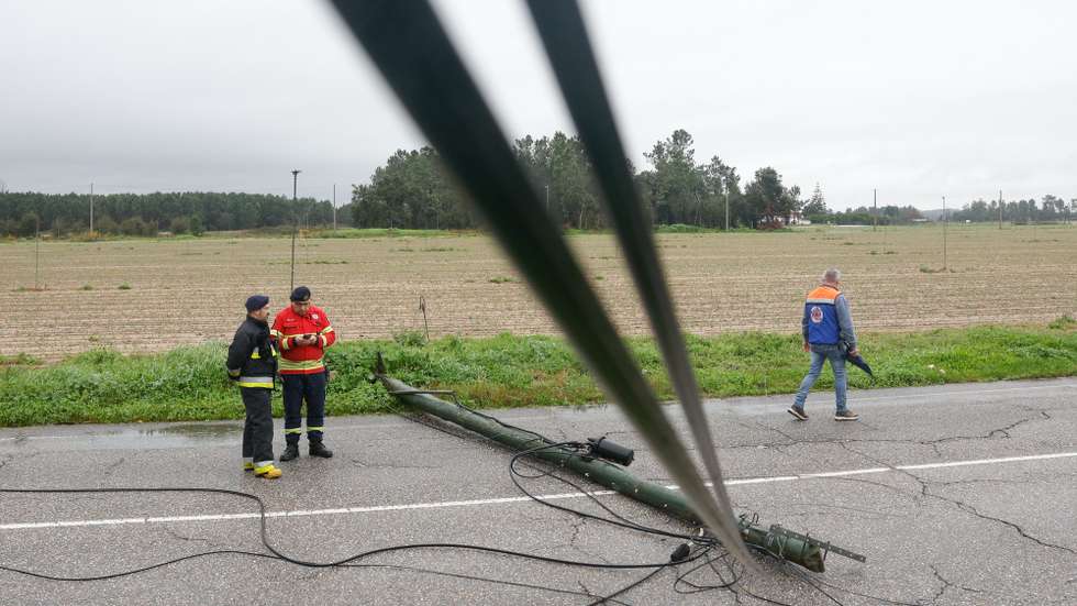 Dois bombeiros e um elemento da Proteção Civil observam um poste de eletricidade destruído devido ao mau tempo, em Salvaterra de Magos, 09 de fevereiro de 2026. Onze pessoas morreram em Portugal desde a semana passada na sequência da passagem das depressões Kristin e Leonardo, que provocaram também algumas centenas de feridos e desalojados. ANTÓNIO PEDRO SANTOS/LUSA