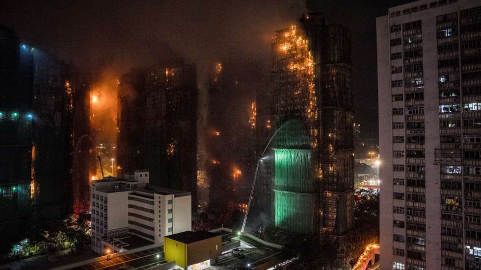 epa12550222 Firefighters spray water at an apartment fire in Tai Po in Hong Kong, China, 26 November 2025. According to the Hong Kong government, the five alarm fire, which started 26 November, has left at least 13 people dead and three in critical condition.  EPA/LEUNG MAN HEI
