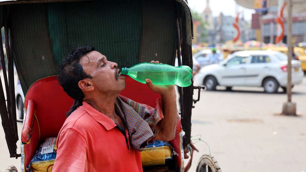 epa12904478 An Indian rickshaw puller drinks water during a hot afternoon in Kolkata, India, 21 April 2026. As a heatwave continues across West Bengal, temperatures are forecast to reach as high as 39 degrees Celsius, according to the India Meteorological Department (IMD).  EPA/PIYAL ADHIKARY