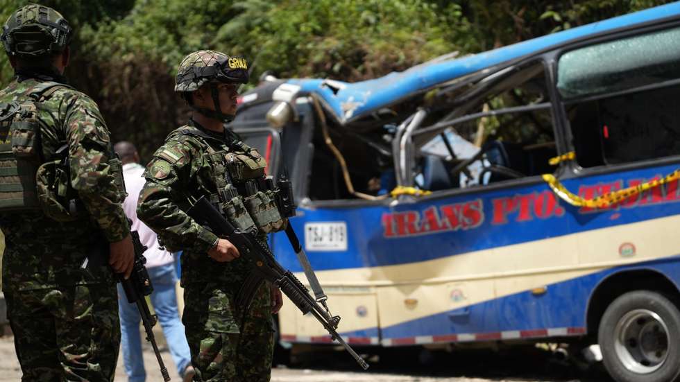 epa12916042 Members of the Colombian National Army stand guard at the site of a guerrilla attack involving a gas-cylinder bomb on the Pan-American Highway in Cajibio, Colombia, 26 April 2026. At least 19 people were killed in the attack, according to Colombia's National Institute of Legal Medicine and Forensic Sciences.  EPA/ERNESTO GUZMAN
