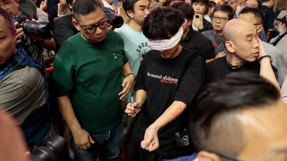 epa13015331 Plain clothes police watch an activist perform near Victoria Park, in Hong Kong, China, 04 June 2026. The park is historically where the now-disbanded Hong Kong Alliance in Support of Patriotic Democratic Movements of China organised annual candlelight vigils since 1990 to mourn the victims of China's 1989 Tiananmen Square crackdown. The vigil, once the only large-scale public commemoration of the crackdown on Chinese soil, has been banned since Beijing imposed a national security law on Hong Kong in 2020.  EPA/MAY JAMES