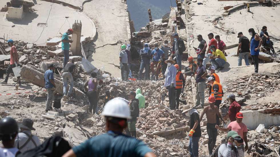 epa13073170 Volunteers conduct search operations in a building damaged by an earthquake in La Guaira, Venezuela, 29 June 2026. National and international rescue teams continue their efforts among the ruins of buildings in the coastal state of La Guaira, north of Caracas, the epicentre of devastation caused by 7.2- and 7.5-magnitude earthquakes, where logistics centres for international teams have been set up.  EPA/RONALD PENA R